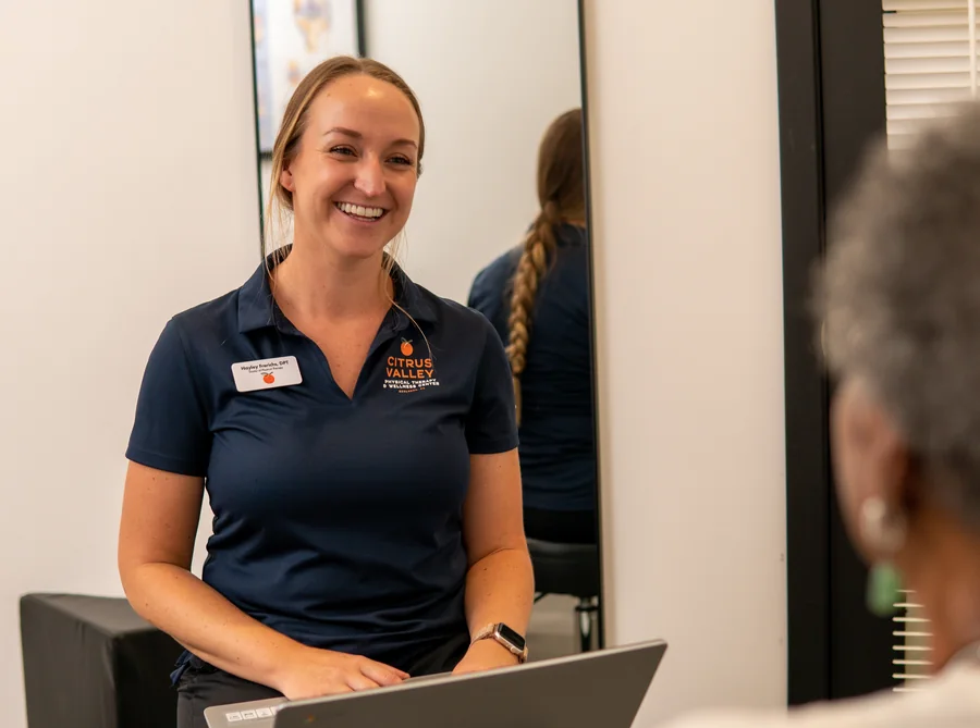 Citrus Valley physical therapist smiling while documenting a patient visit on a laptop