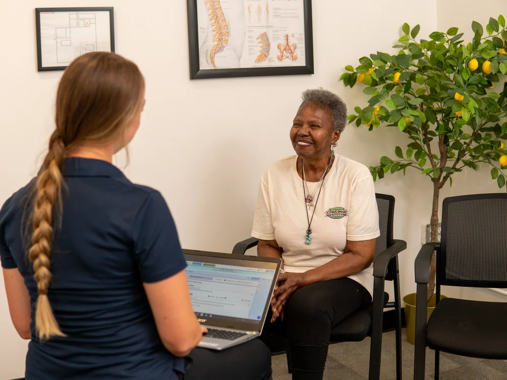 Citrus Valley physical therapist reviewing a plan of care on a laptop with a smiling patient