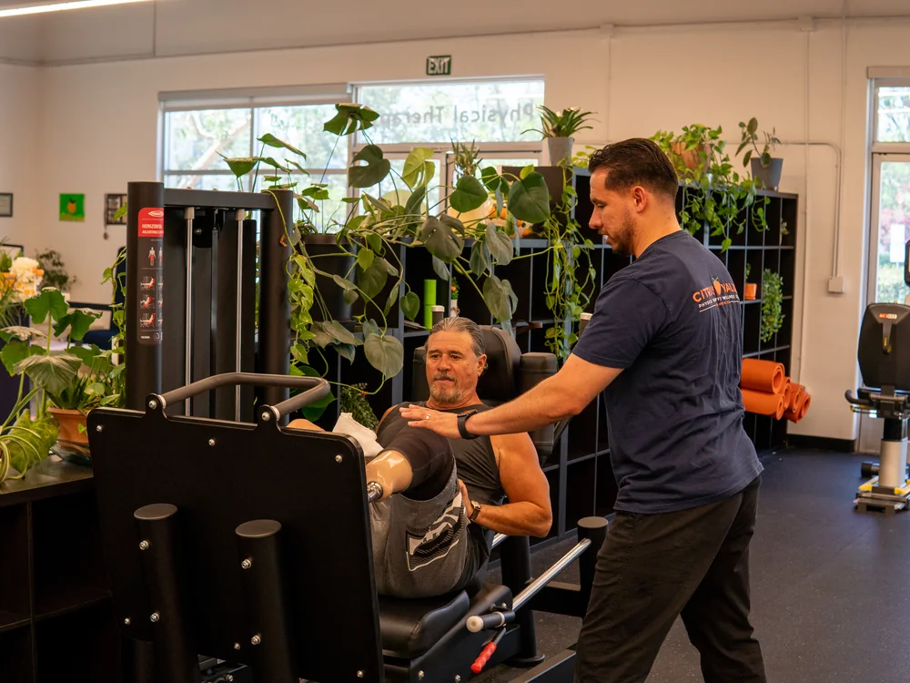 Physical therapist guiding a patient through a leg press